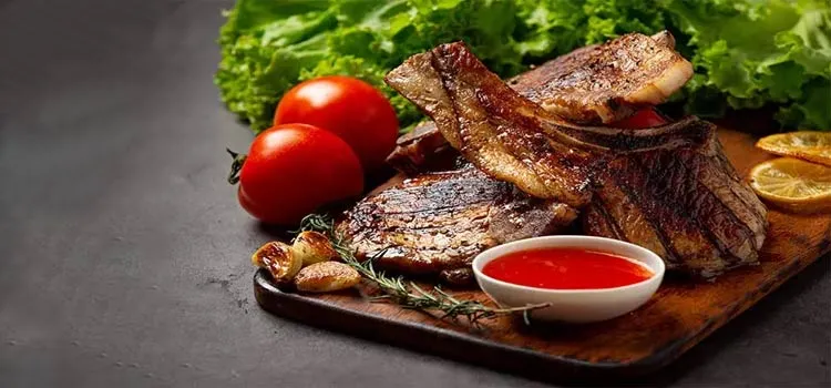 Grilled pork steak served with ketchup, garlic and lettuce