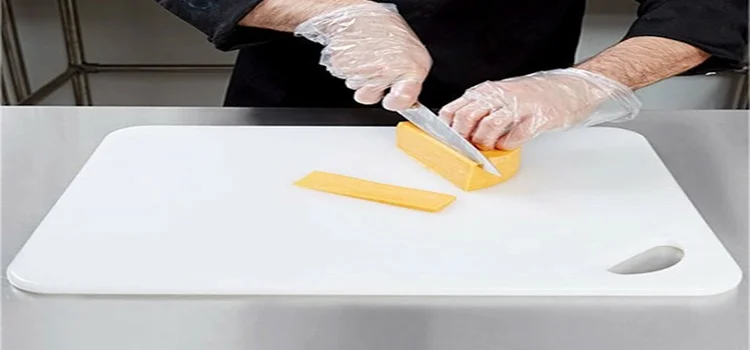 a man is slicing cheese on a white chopping board