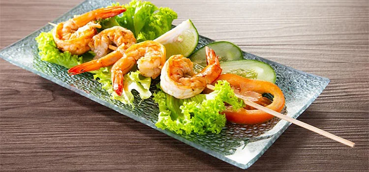 Fried prawns in a stick served with fresh lettuce, cucumber and tomatoes 
