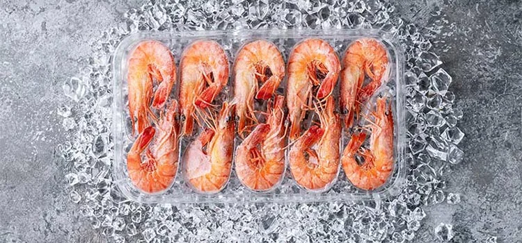 Frozen large prawns in a case with ice in it