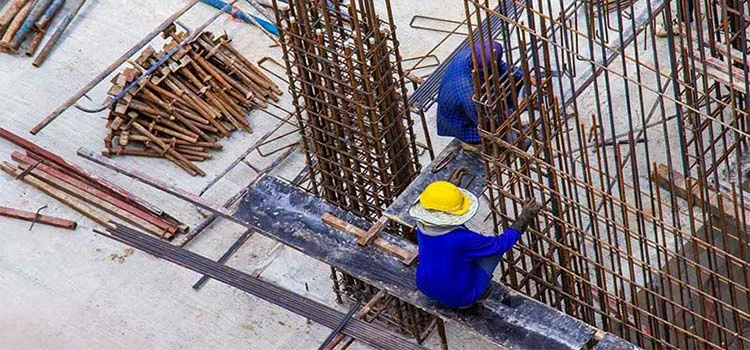 Construction workers working with steel and rods wearing a helmet 