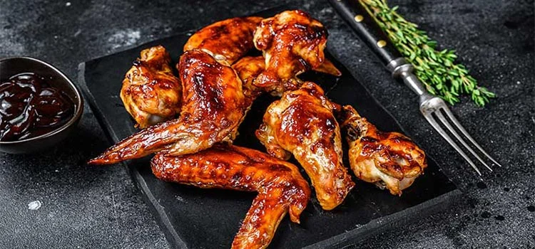 Barbecue chicken wings with barbecue sauce served in a black dish