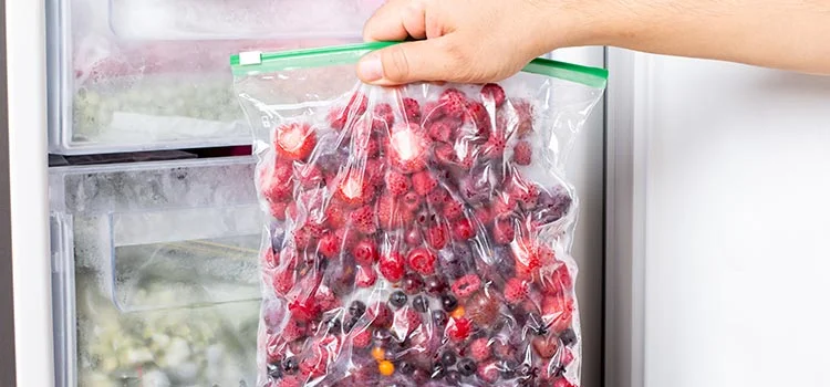 Close-up of frozen berries in transparent plastic bags in the freezer