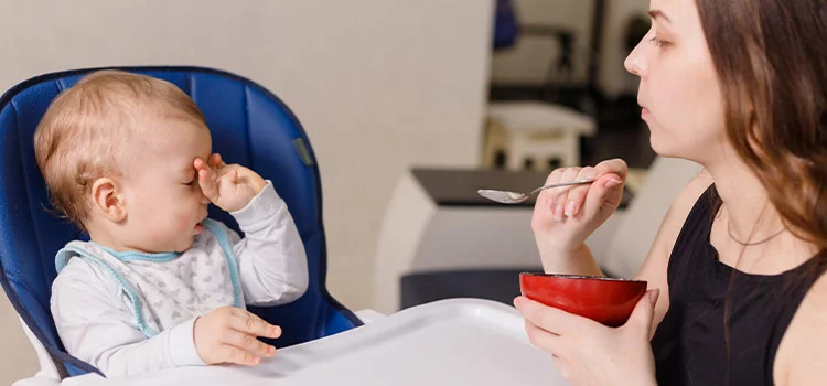 Naughty infant kid becoming fussy and refusing to eat.