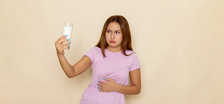 Young girl in pink t-shirt having stomachache due to milk. 