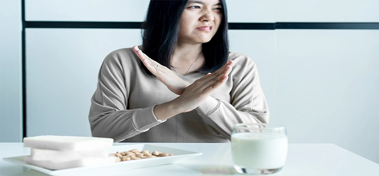 Lactose intolerance concept of woman having stomach pain with a glass of milk. 