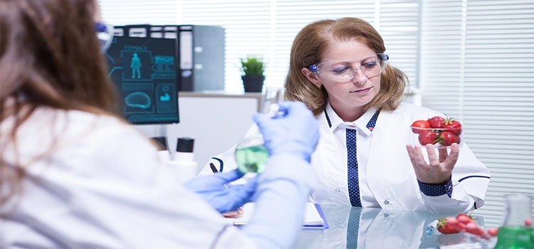 Female scientist looking at strawberries in her research lab.