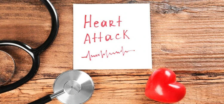 Stethoscope note with phrase heart attack and small red heart on wooden background