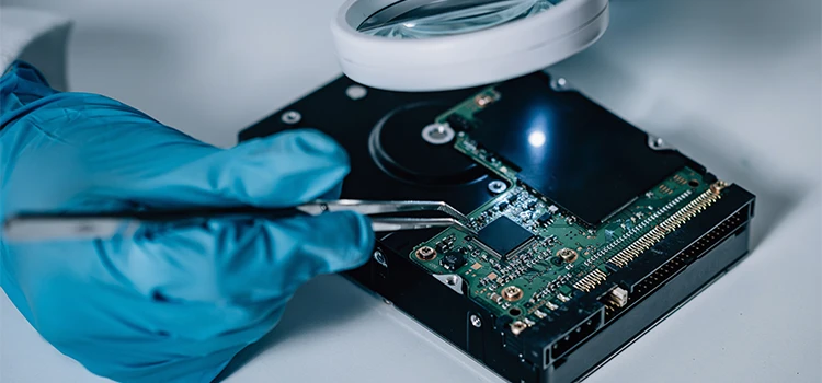 Close-up of forensic Scientist examining hard drive with evidence