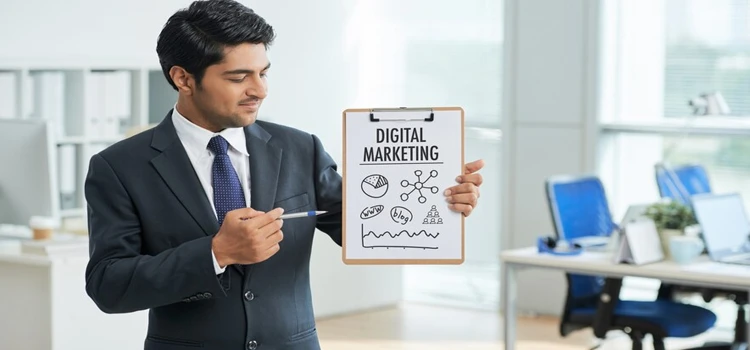 Man in suit standing in office with clipboard and pointing to poster with words Digital Marketing. 
