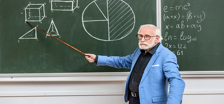 Professor pointing at something with a wooden pointer at chalkboard